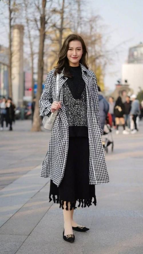 时髦裙子外搭黑白格大衣，展现高挑挺拔的身材