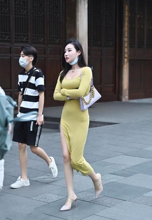 美女穿一条粉色的风衣裙,看起来优雅大方,气质迷人