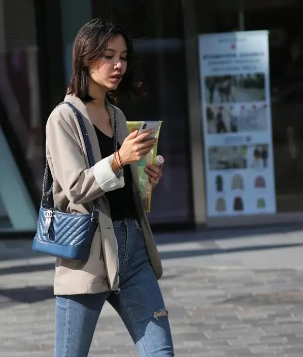 街拍名嫒美姝的美女,身穿V领上衣配灰色裤子,彰显时尚达人气质