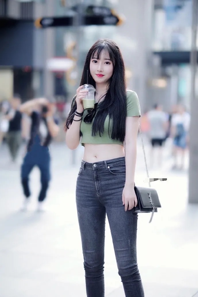 五官精致的小姐姐留着黑直长,穿着绿色的短T恤和牛仔裤,可爱又好看