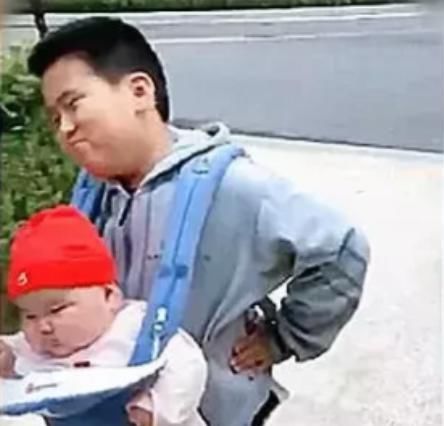 兄妹|兄妹相差12岁，哥哥抱妹妹出行一脸无奈：比我上学的书包重多了