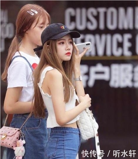 白色|街拍:小姐姐穿着白色的吊带背心搭配牛仔长裤,气质甜美性感