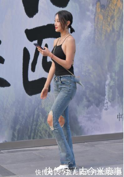 牛仔裤 黑色吊带搭配开洞的牛仔裤，设计风格独特，层次感丰富