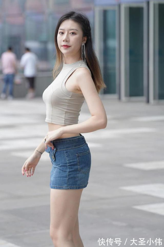 无袖背心 美女街拍:短款无袖背心搭配牛仔短裙,凸显香肩、小蛮腰和美腿,魅力炸街