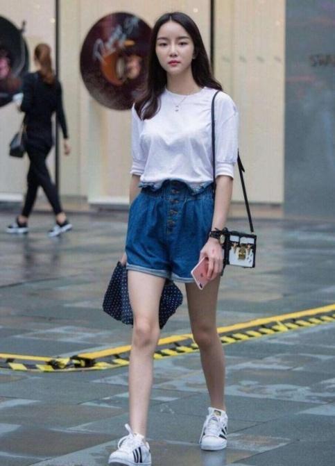 街拍:身材凹凸有致的小美女,短款上衣配短裤,十分靓丽动人