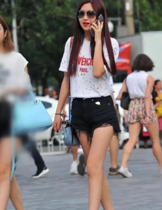 街拍皮肤白皙的美女,身穿黑色连衣裙,女人味十足