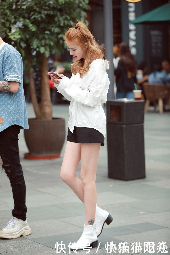 短裤|街拍黑色的短裤搭配了一件雪白的衬衫,展现了一种潮流的前卫感