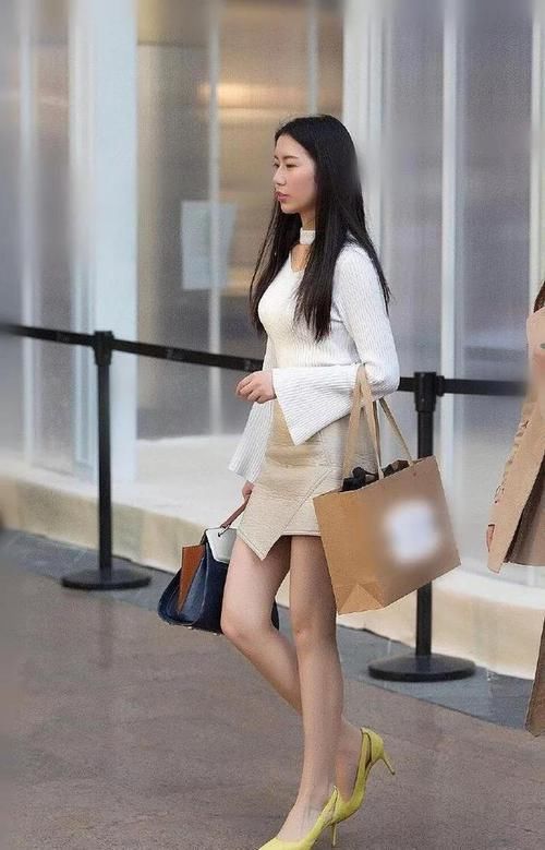 美女脚上搭配一双淡黄色的尖头高跟鞋,显得特别的时尚靓丽