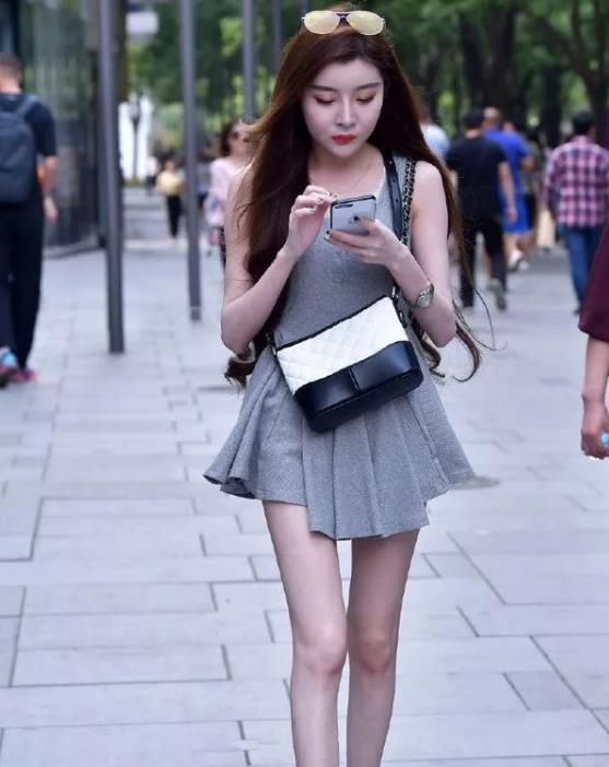 街拍:专注手机的小姐姐,身穿灰色连衣裙,超有范