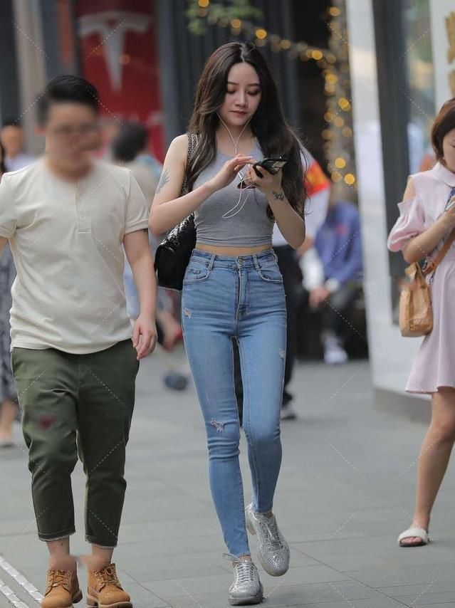 灰小衫，与浅色牛仔裤的组合，展现了十足的街头休闲范儿