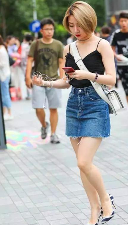 街拍：白色连衣裙穿出了美女的好身材，撩发的姿势也很是动人