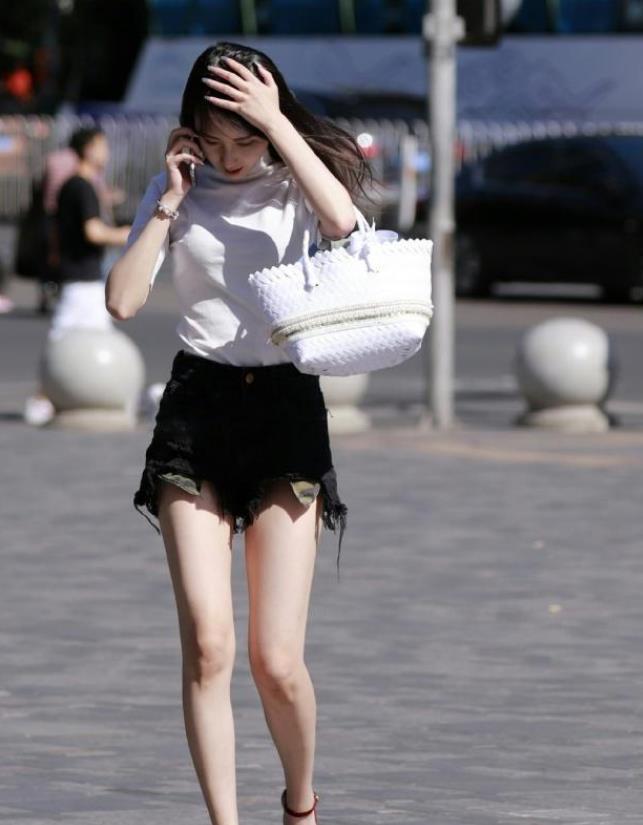 小姐姐|街拍小姐姐吊带的黑色上衣搭配牛仔短裤,清凉而又不失个性