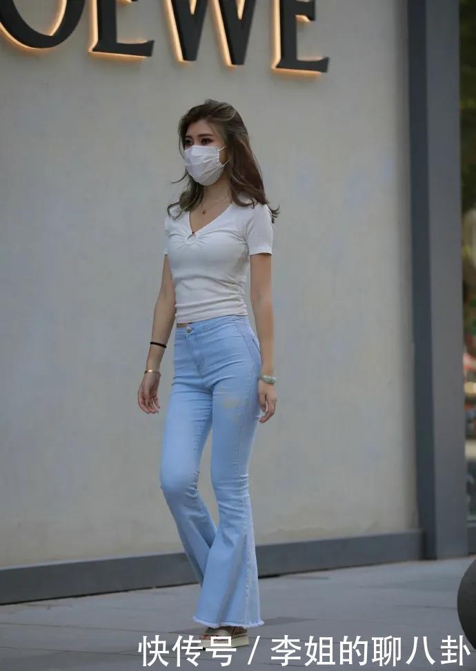 视觉疲劳|白色V领修身T恤，加上喇叭牛仔裤，尽显出休闲时尚的风格