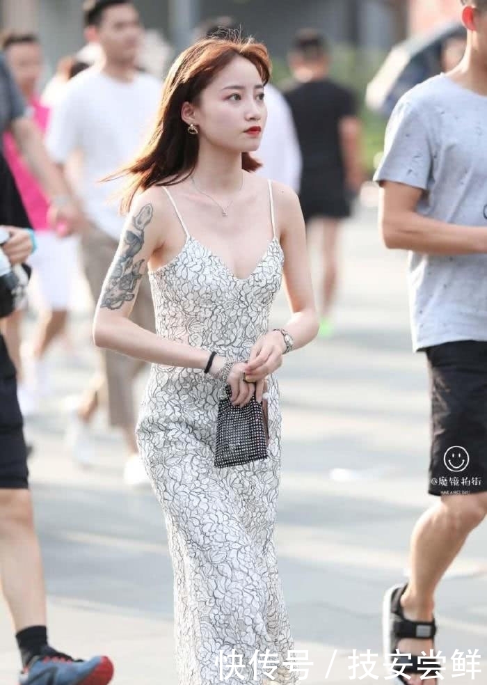 街拍:小姐姐身穿一条白色印花吊带裙,性感中带着一丝文艺小清新