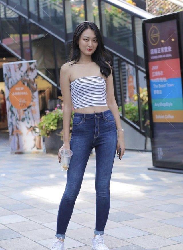 一套条纹胸衣吸引了路人的眼球，而经典的高腰牛仔裤则突出了长腿