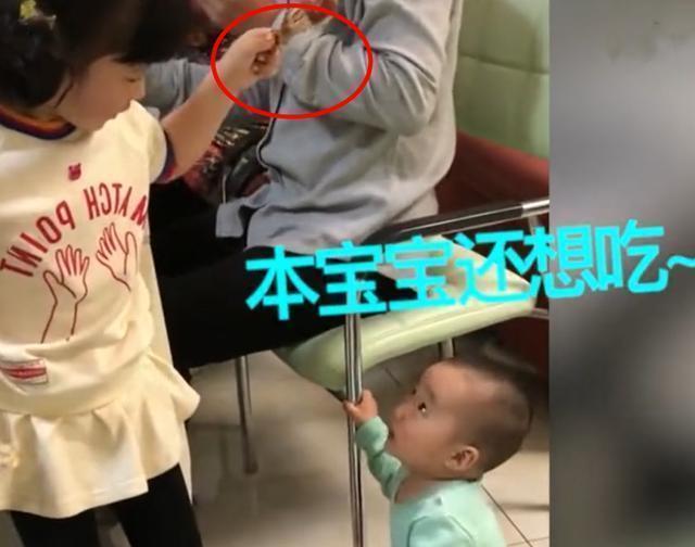 弟弟趁着姐姐看电视，站在姐姐旁偷吃鸡腿，姐姐一低头被萌到了