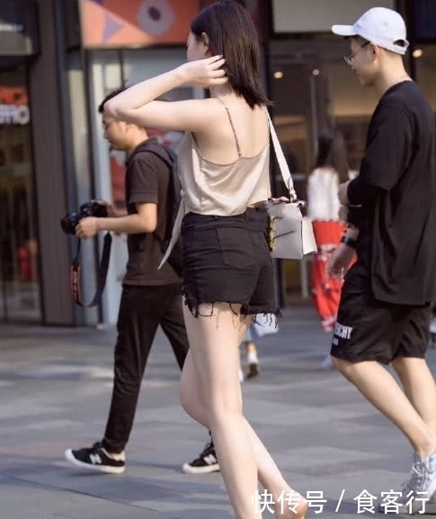 上半身穿着一件吊带衫,胸前的系带增添了设计感显得不再单调