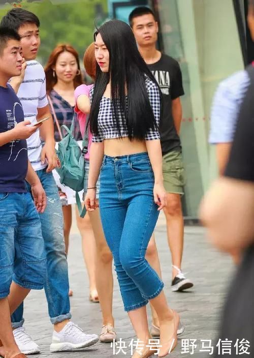 街拍小姐姐半袖上衣搭配黑色的短款下装,非常时尚具有美感