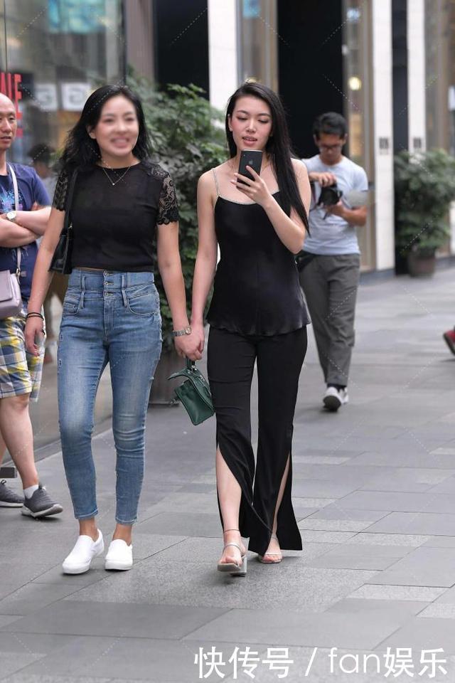 小姐姐黑色喇叭裤搭配了一件吊带衫,展现出了几分随性慵懒的格调