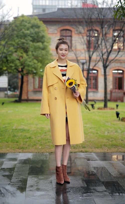 路人街拍，肩上挎着一个白色单肩桶包，凸显了美女干净的外形