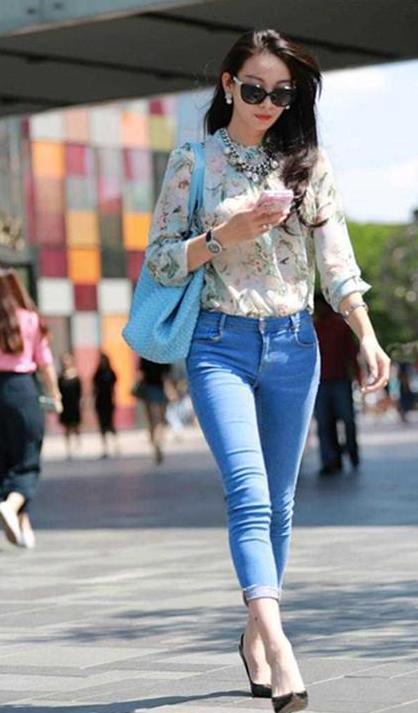 街拍:白色连衣裙穿出了美女的好身材,撩发的姿势也很是动人