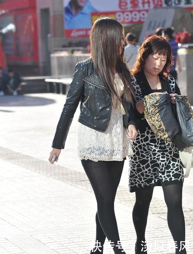 街拍：美女黑色上衣搭配黑色丝袜，身姿优美，美腿修长，让人心动