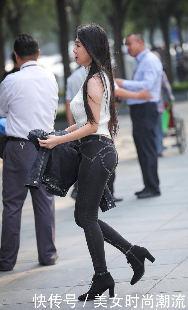 白色的无袖针织衫,搭配黑色的修身牛仔裤,彰显成熟女性的魅力