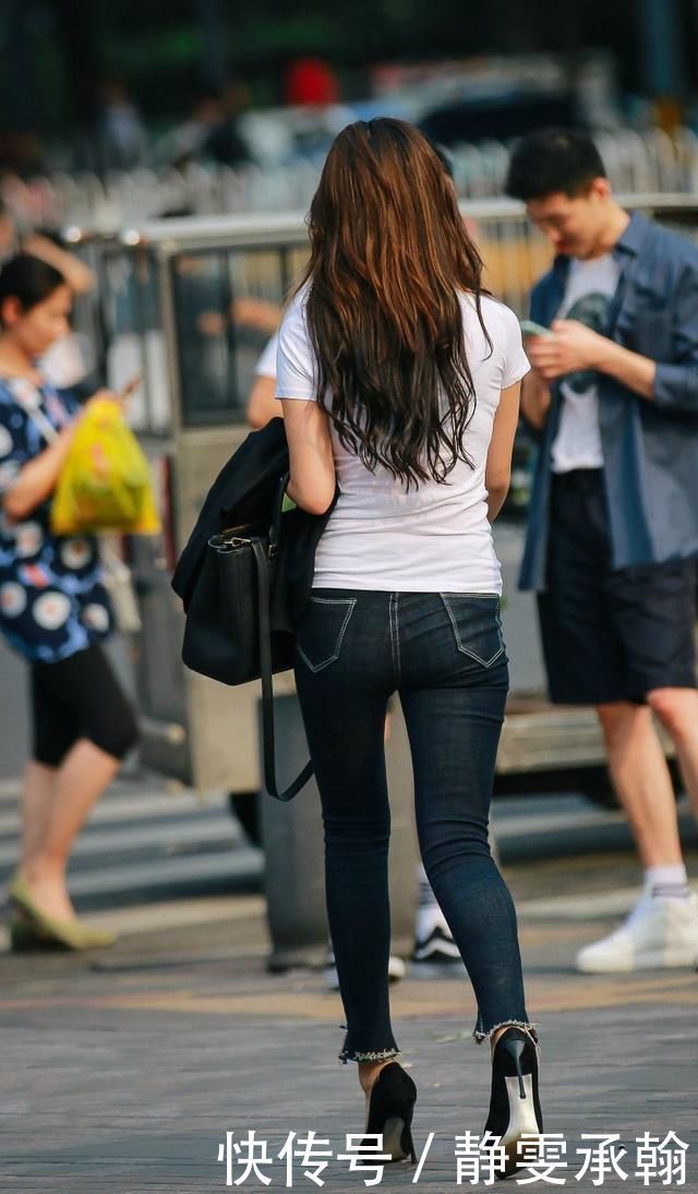 紧身牛仔裤搭配细高跟鞋,展现出时尚美女的纤细身姿