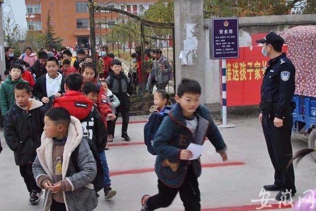 淮南市中小学校24日开学，民警为学生撑起“平安伞”