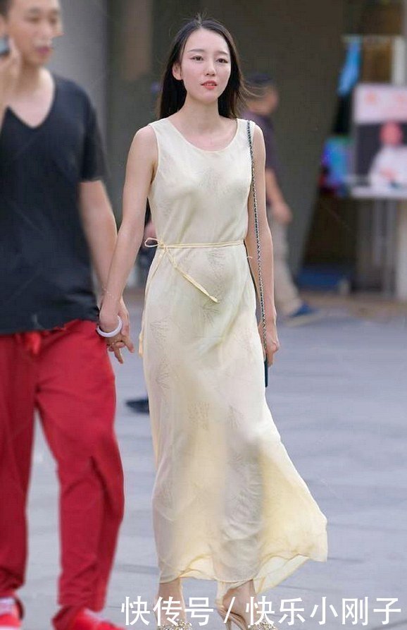 淡黄色的连体长裙，采用了修身的剪裁，展现出几分利落个性的美!