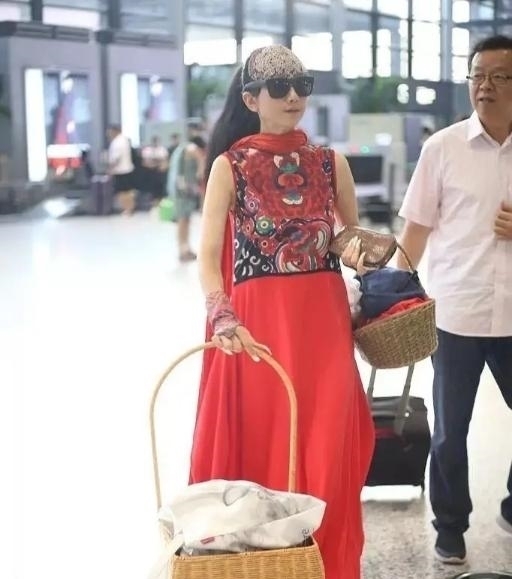 机场|60多岁的杨丽萍活出了自信,穿红色民族裙走机场,推竹筐好洋气
