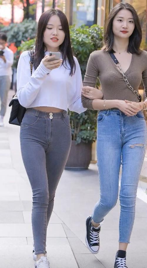 街拍时尚靓丽的两姐妹,同穿修身牛仔裤各有千秋,你选谁