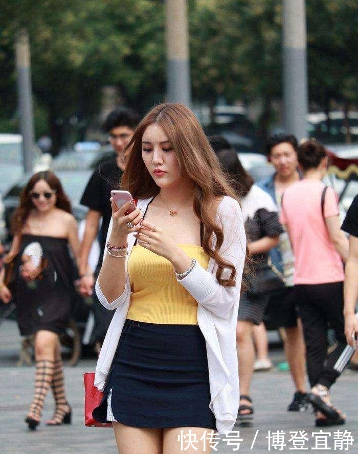 黄色打底上衣搭配深色短裙,美女的身材尽显!