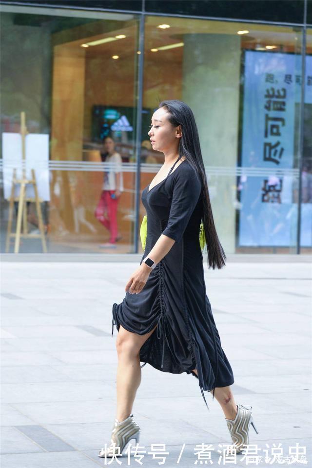 微胖身材的姑娘，穿着黑色连衣裙，搭配银色露趾细高跟踝靴