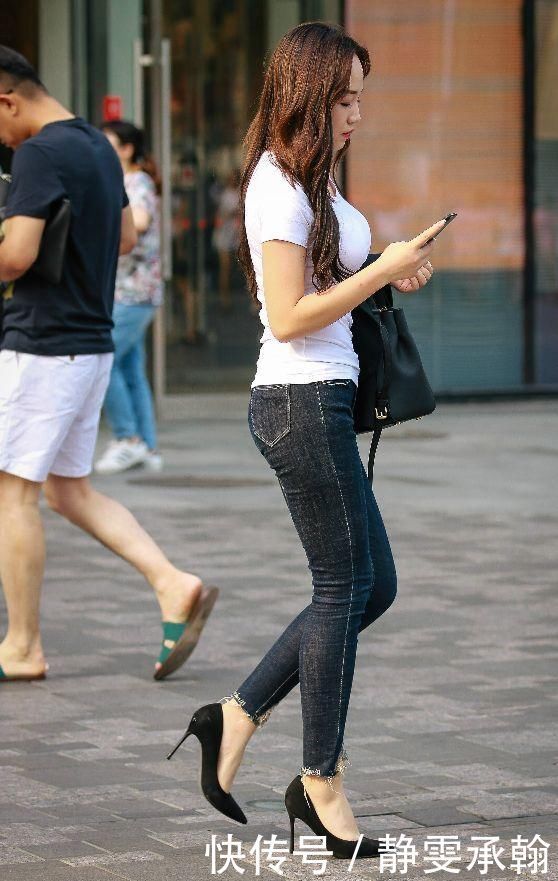 紧身牛仔裤搭配细高跟鞋,展现出时尚美女的纤细身姿