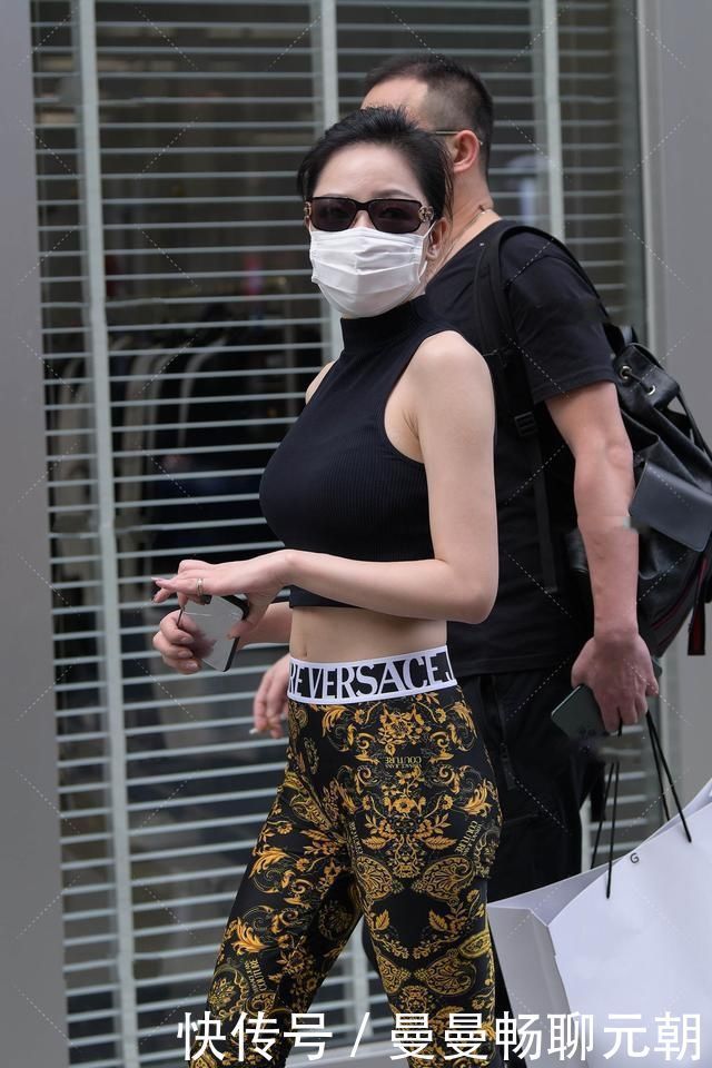 阿姨黑色半高领上衣搭配花纹修身裤,设计精美,尽显时髦气息