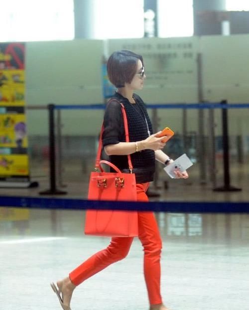 马伊琍穿黑色上衣，搭橙红色的休闲裤，打扮时髦且拉风！