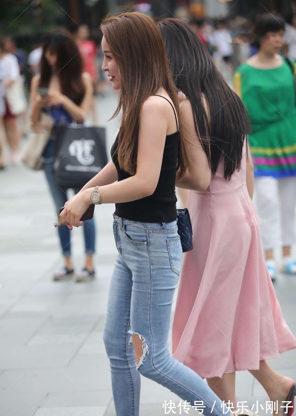 紧身牛仔裤 小姐姐身穿黑色吊带,搭配蓝色紧身牛仔裤,看上去时尚大方