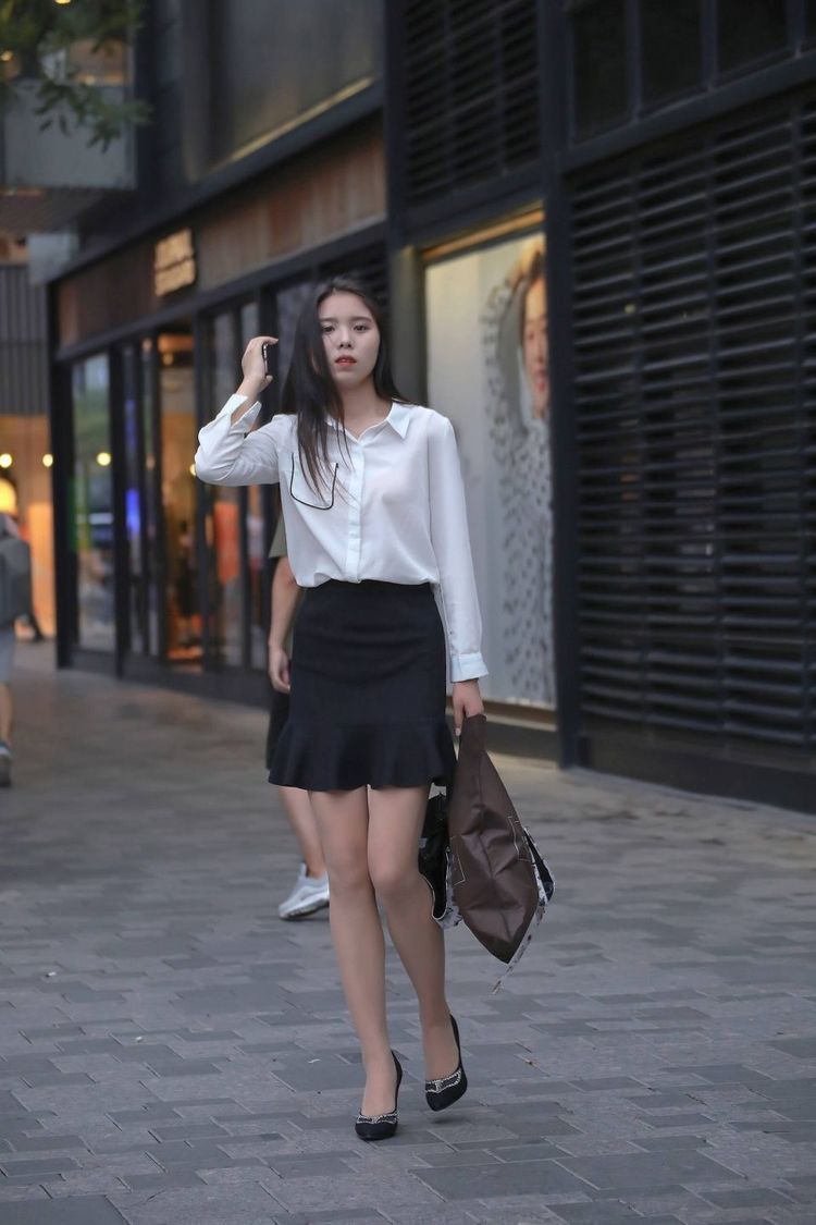 街拍黑色迷你短裙白色衬衫，标准的职业装，掩盖不了秀气的面庞