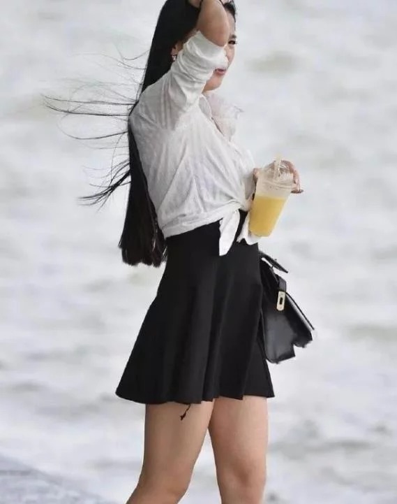 街拍皮肤白皙的美女,身穿黑色连衣裙,女人味十足