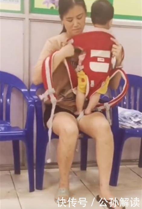 医院|医院走廊里,一位宝妈抱着孩子,看到她的一身打扮后不禁有些鼻酸