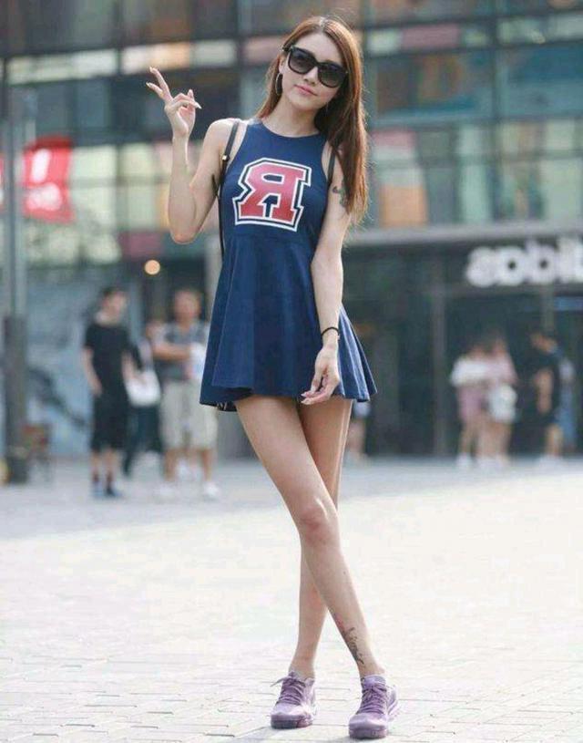 路人|路人街拍，美女搭配着绿色半身裙，十分吸晴