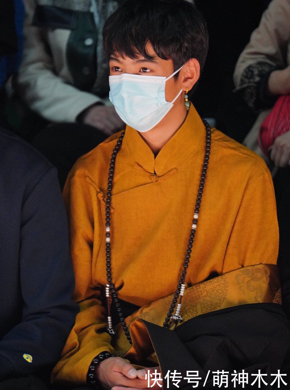 丁真首次亮相上海时装周，换上全套妆发造型看秀，为设计师献花