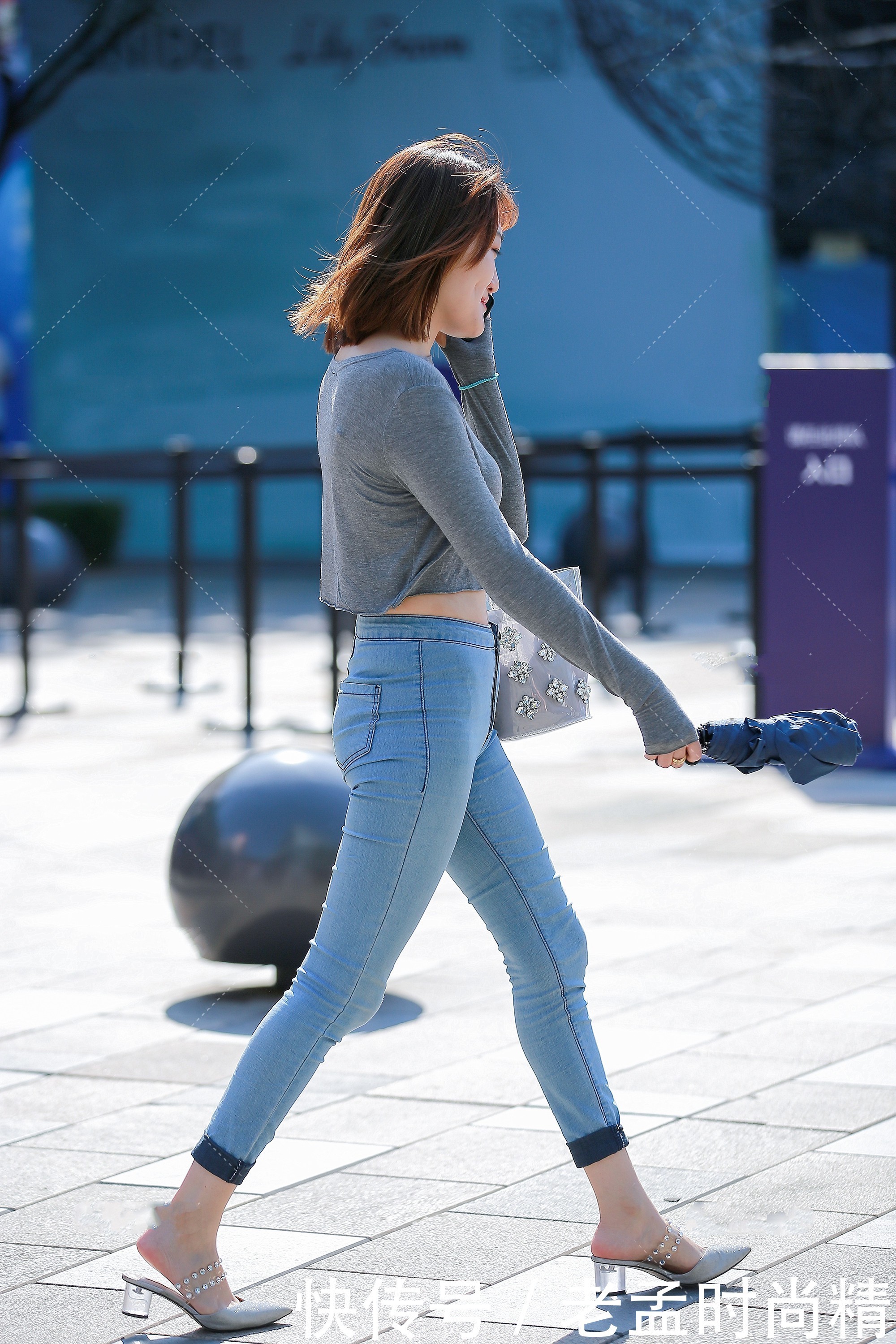 牛仔裤|街拍:灰色短款修身上衣,搭配浅蓝色经典牛仔裤,简约大方又不失时尚