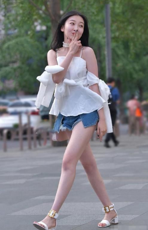 白色吊带儿上衣搭配蓝色短裤,脚踩个性高跟凉鞋,也不失为时尚
