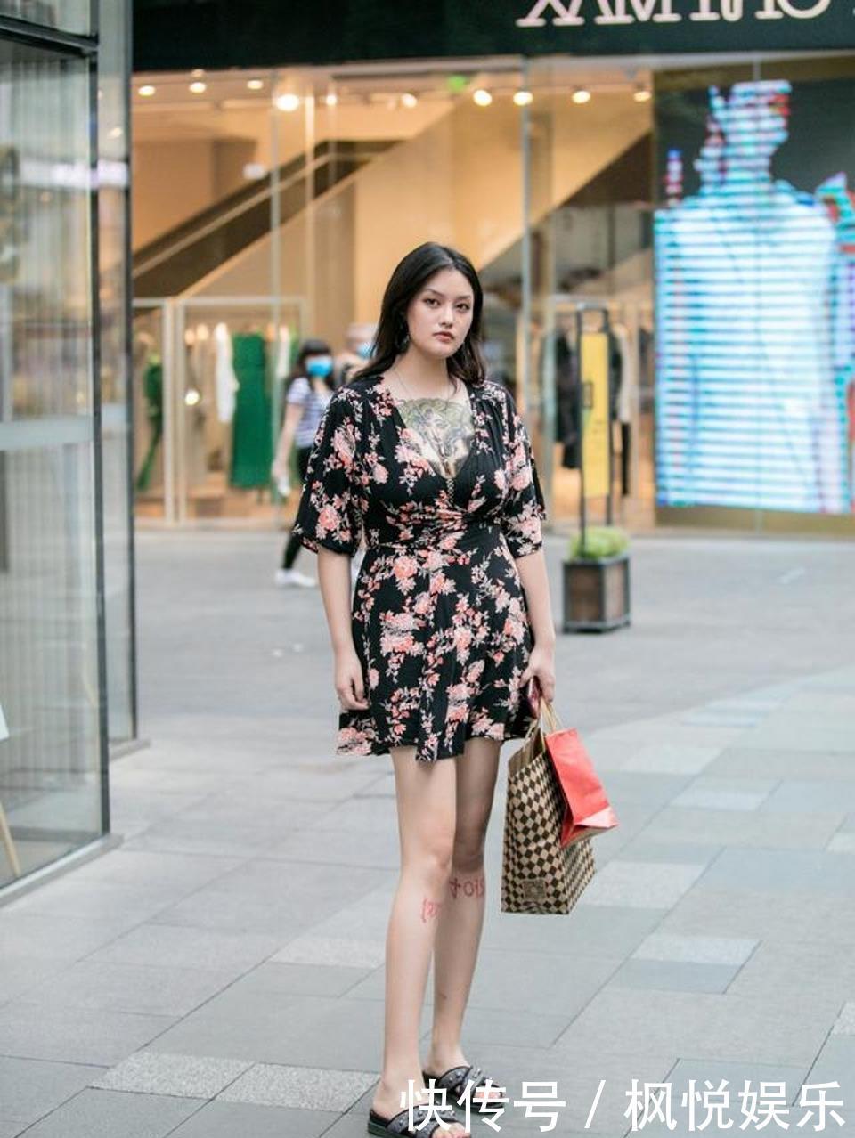 小姐姐身材丰盈且性感，选择深V款碎花裙，很抢眼