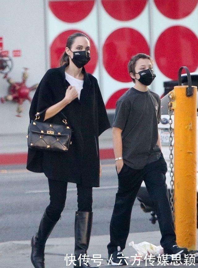 安吉丽娜·朱莉穿黑色斗篷上衣搭配细腿裤,和儿子逛街,真潇洒
