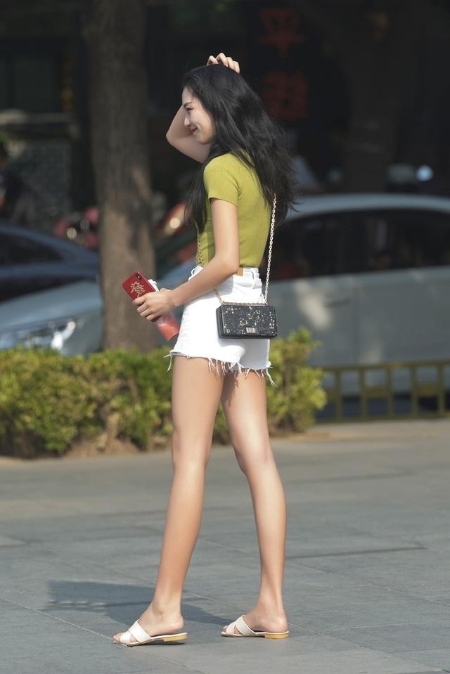 路人街拍，小姐姐搭配清新简洁的白色短裤，显得元气满满