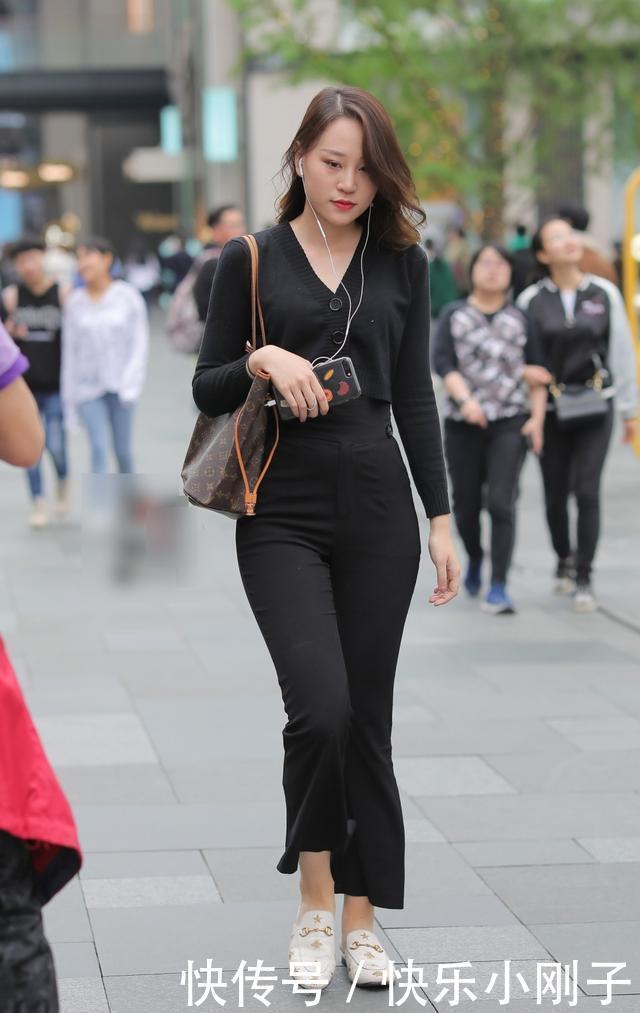 黑色的紧身T恤,搭配黑色喇叭裤,凸显出十足的女人味