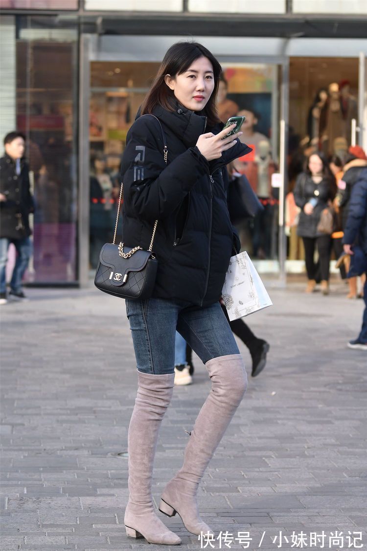 街拍 街拍:美女搭配黑色羽绒服,选择牛仔裤和过膝靴,别样的时尚味道